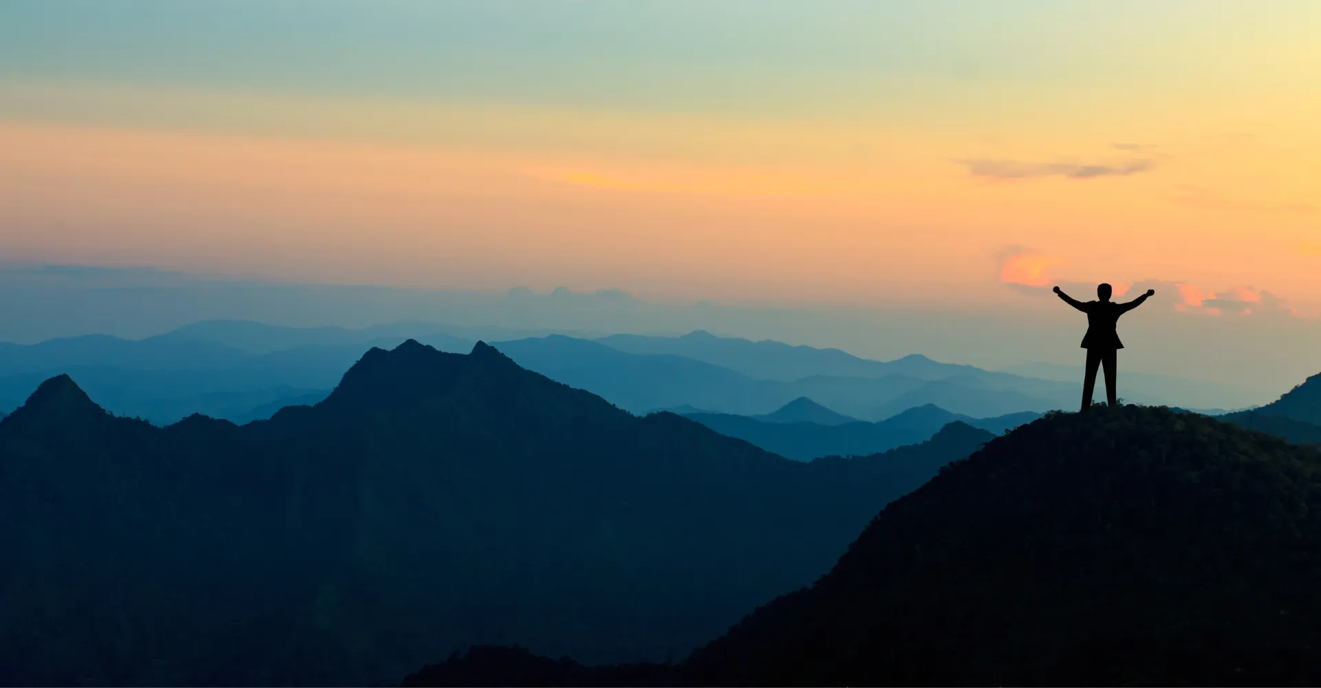 Pessoa observando novos caminhos no topo de uma montanha, simbolizando conquistar muito mais.